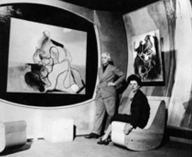 Art of This Century Gallery, 30W. 57th Street, New york City, 1942 Szürrealista Terem a dél-amerikai gumifából készült ívelt falakkal, keret nélküli festményekkel. A Kiesler tervezte korrealista ülőalkalmatosságon Peggy Guggenheim foglal helyet, mellette Max Ernst áll. © Guggenheim Museum Archives Collections