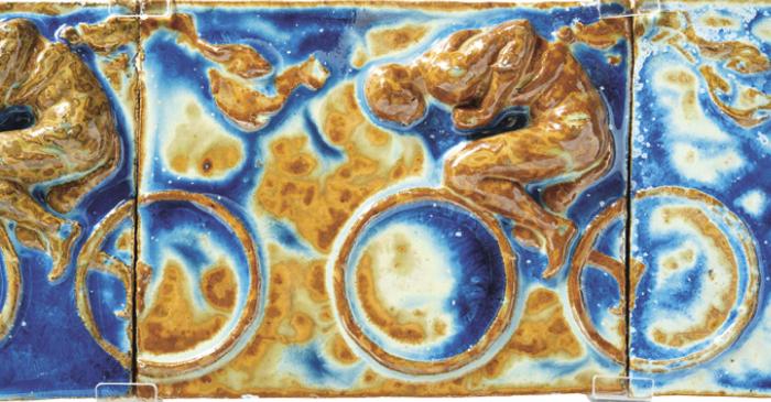 Fríz kerékpárosok alakjával, 1900 előtt, terv: Pierre Roche, (vagyis Fernand Massignon), kivitelező: Bigot & Cie, Mer Loire-et-Cher gres (azaz formába préselt, színes mázakkal festett kerámia), 48,8 × 105,6 × 9,5 cm © Fotó: Áment Gellért © Iparművészeti Múzeum